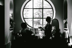 Deux personnes discutent devant une fenêtre